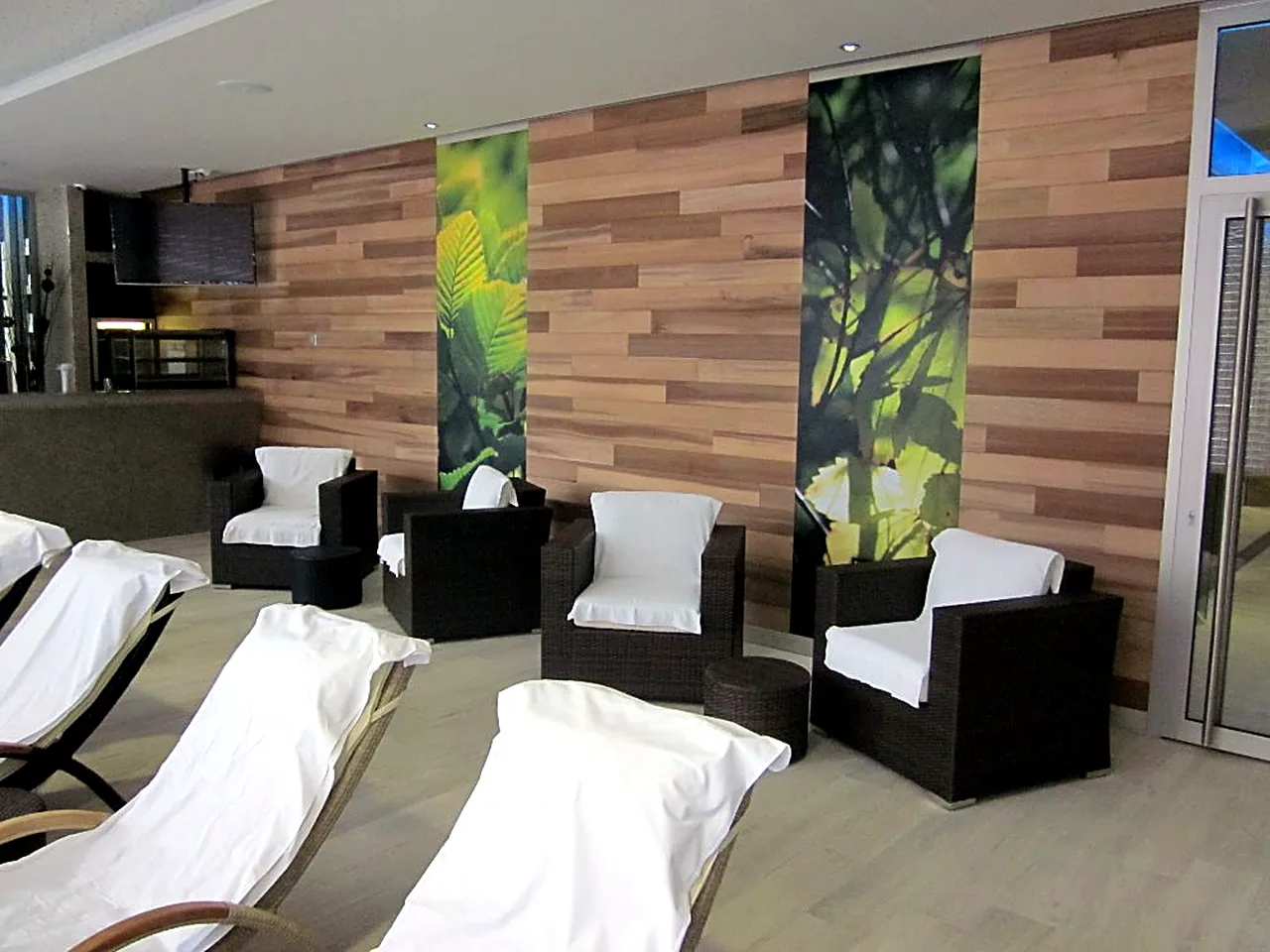 Wellness s dřevěným obkladem stěny, lehátky a křesly